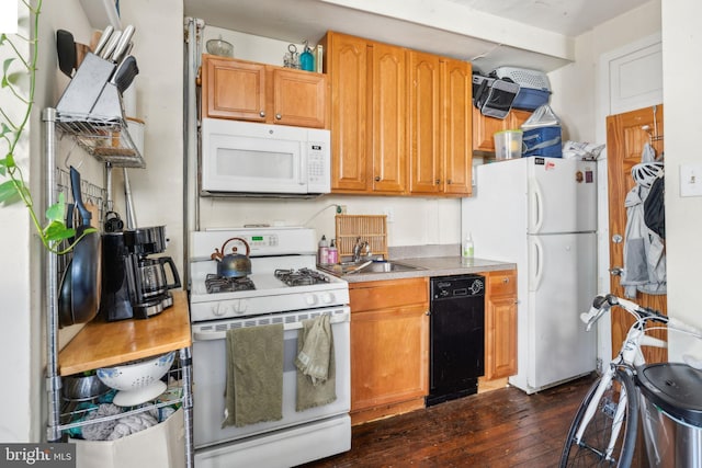 kitchen with sink, dark wood-type flooring, and white appliances