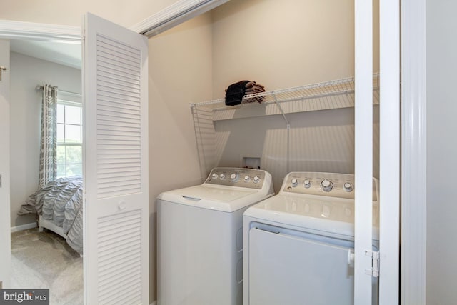 clothes washing area featuring washing machine and clothes dryer and carpet