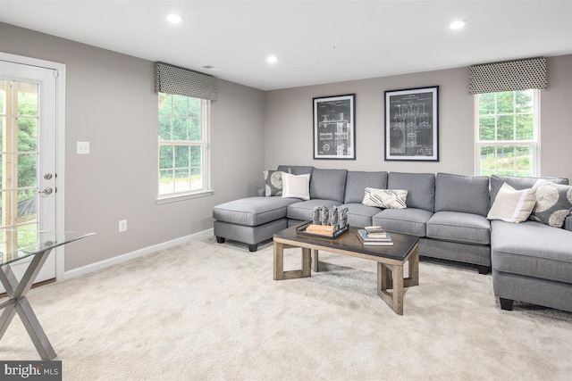 living room featuring light colored carpet and a healthy amount of sunlight