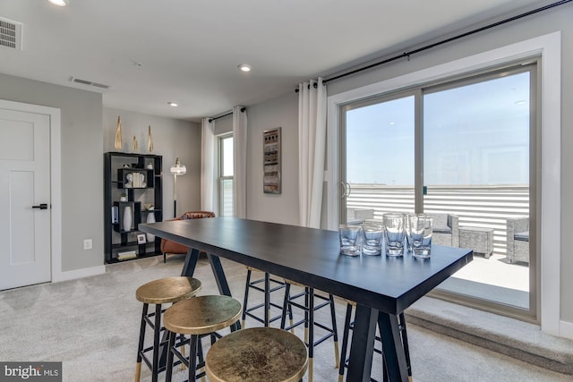 dining area featuring light carpet