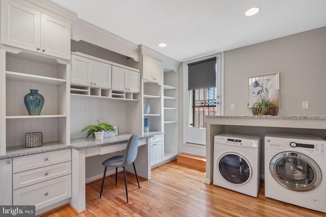 laundry room with washer and clothes dryer, cabinets, and light hardwood / wood-style floors