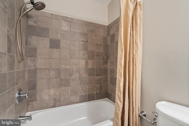 bathroom featuring shower / tub combo and toilet