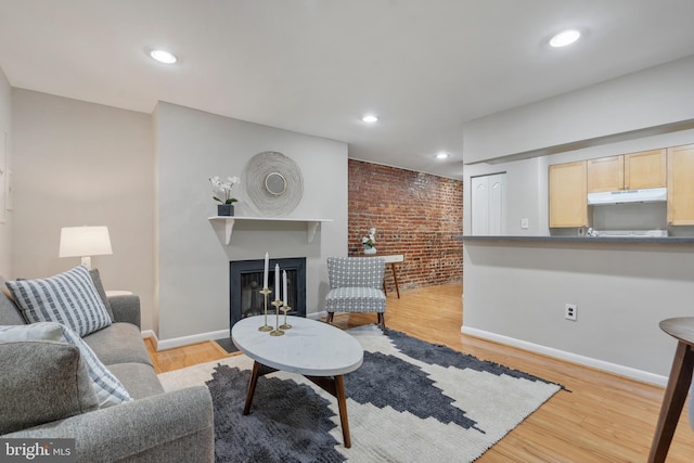 living room with light wood-type flooring and brick wall