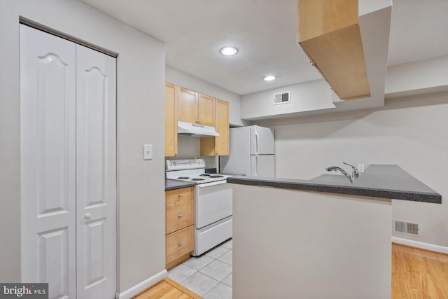 kitchen featuring light brown cabinets, white appliances, and light tile patterned floors