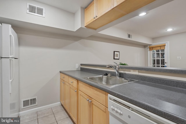 kitchen with light tile patterned flooring, light brown cabinetry, white appliances, and sink