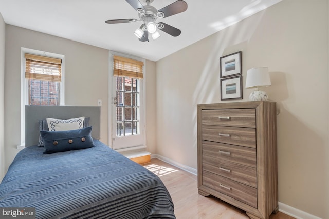 bedroom with multiple windows, light wood-type flooring, and ceiling fan