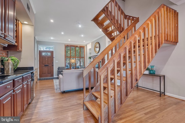 stairway with hardwood / wood-style flooring and ornamental molding