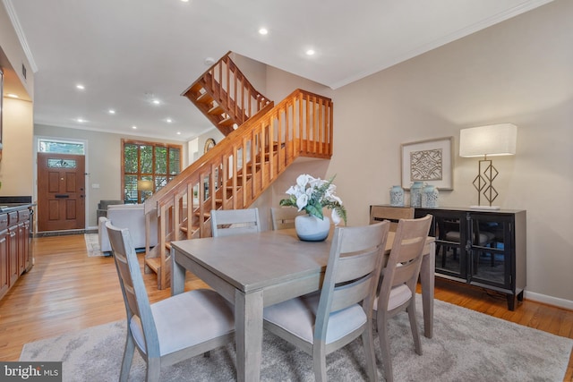 dining area with light hardwood / wood-style floors and crown molding