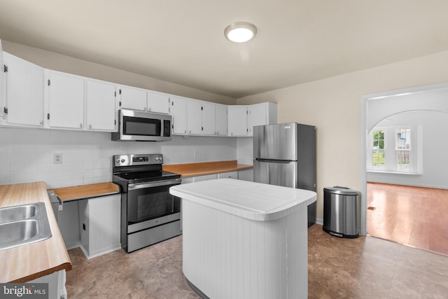 kitchen featuring white cabinets, decorative backsplash, stainless steel appliances, and sink