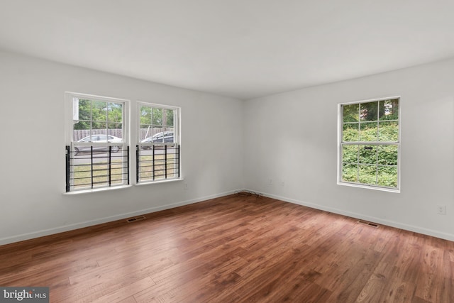 spare room with hardwood / wood-style floors and a healthy amount of sunlight