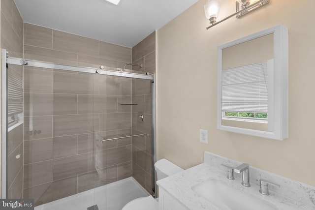 bathroom featuring an enclosed shower, vanity, and toilet