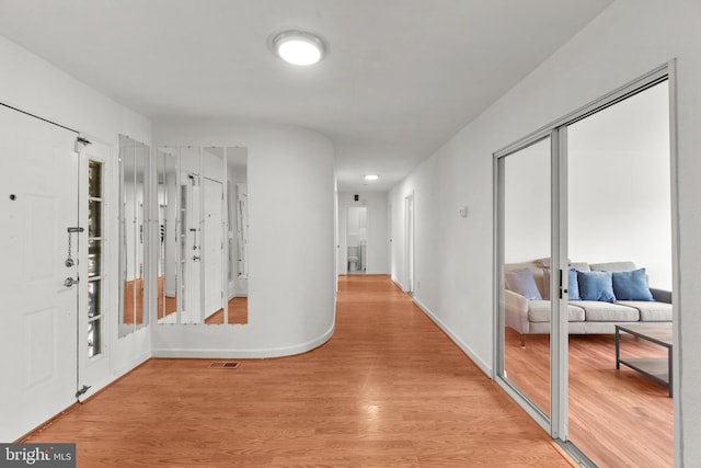 hallway with light hardwood / wood-style flooring