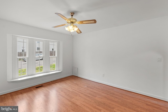 empty room with ceiling fan and light hardwood / wood-style flooring