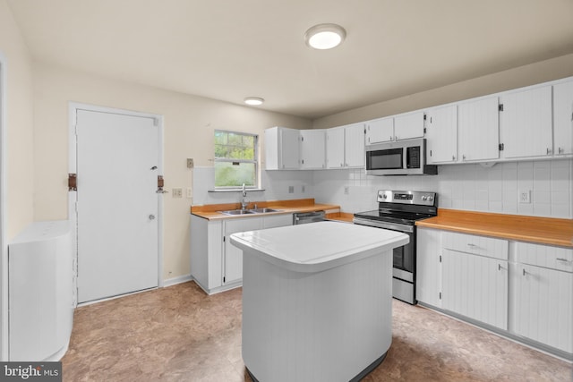 kitchen featuring white cabinets, a center island, sink, and stainless steel appliances