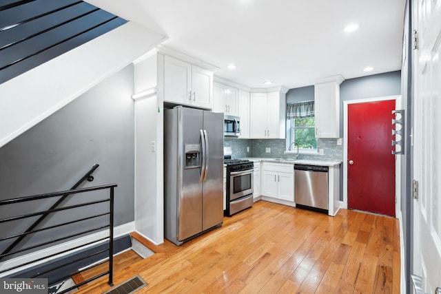 kitchen with backsplash, white cabinetry, sink, and appliances with stainless steel finishes