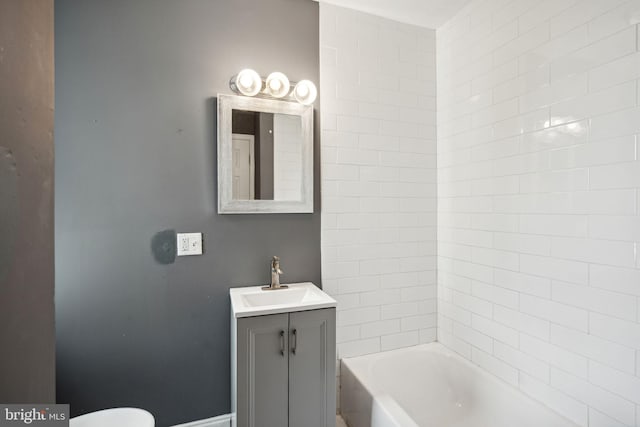 bathroom featuring vanity, toilet, and a tub to relax in