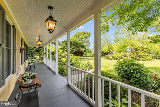 wooden deck with a lawn and a porch