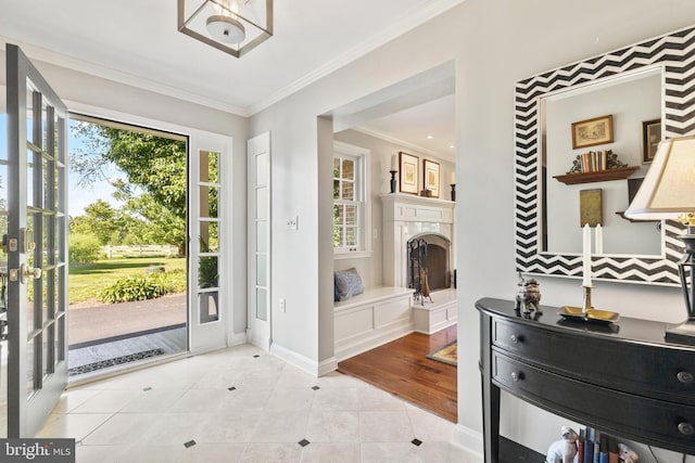 entrance foyer featuring light tile patterned floors, a high end fireplace, baseboards, and crown molding