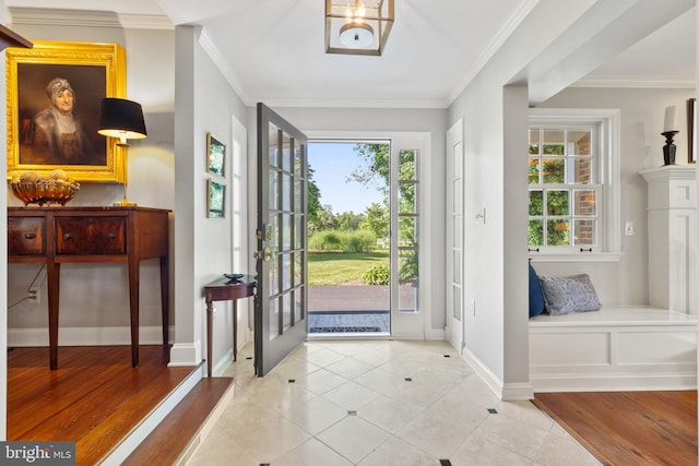 entrance foyer featuring crown molding, light tile patterned floors, and baseboards