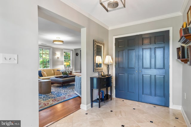 entryway with baseboards, ornamental molding, and tile patterned flooring