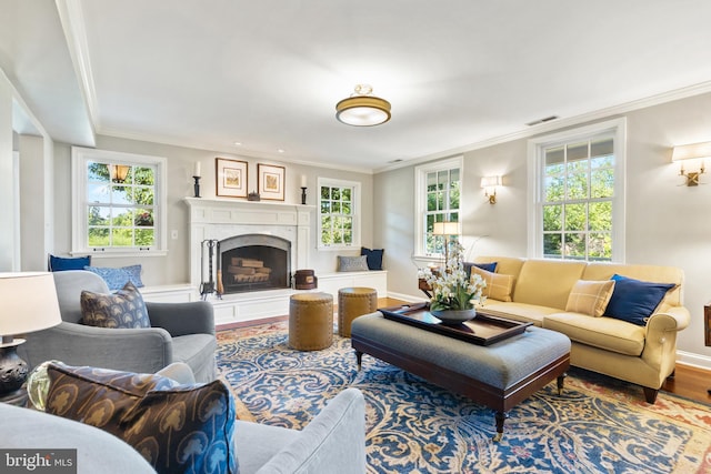 living room featuring crown molding, wood finished floors, and a fireplace with raised hearth