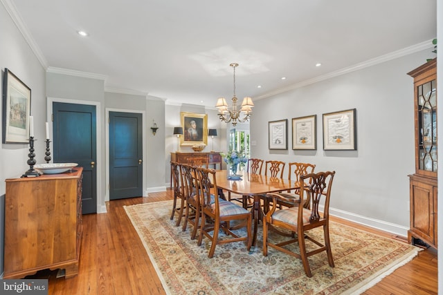 dining room featuring a notable chandelier, light wood-style flooring, crown molding, and baseboards