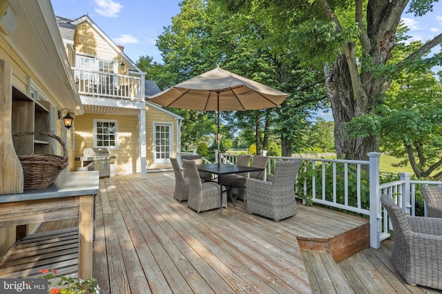 wooden deck featuring outdoor dining area and a grill