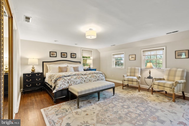 bedroom featuring hardwood / wood-style floors, baseboards, and visible vents