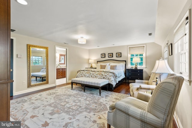 bedroom with visible vents, baseboards, and wood finished floors