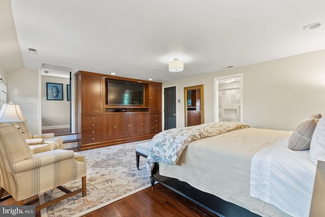 bedroom with visible vents, lofted ceiling, and wood finished floors