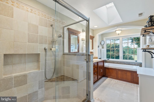 bathroom featuring visible vents, vanity, a skylight, and a shower stall