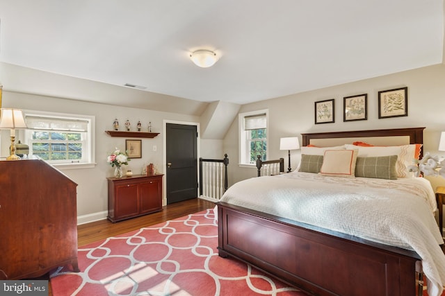 bedroom with visible vents, baseboards, and wood finished floors