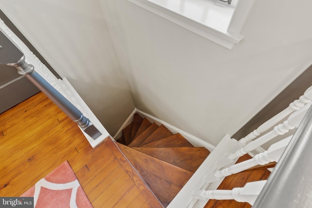 staircase with baseboards and wood finished floors