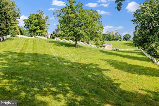 view of yard with a rural view and fence