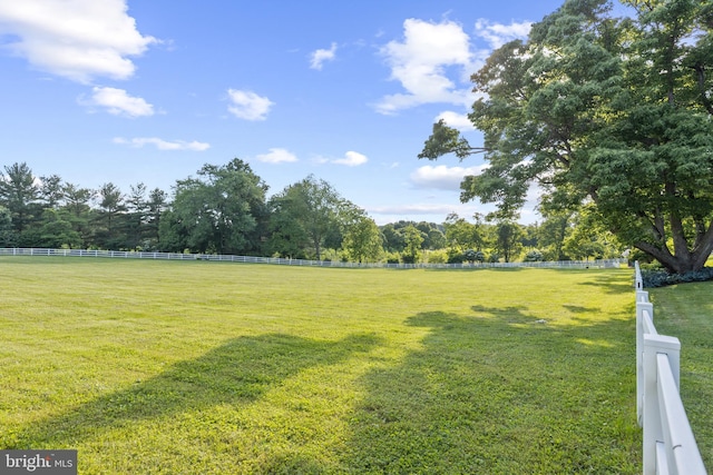 view of yard with a rural view and fence