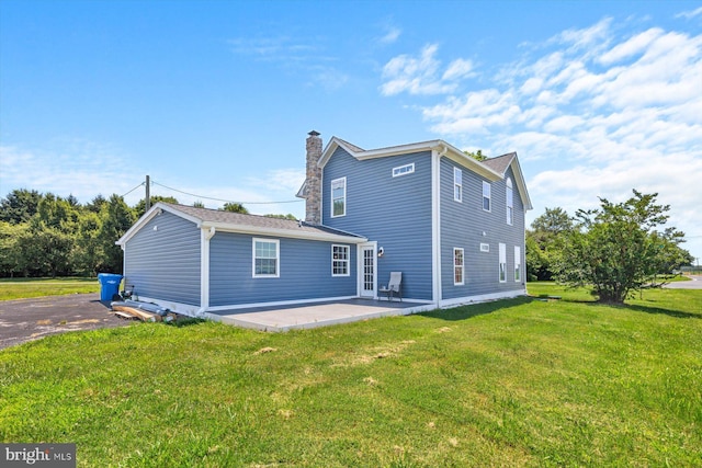 rear view of house featuring a yard and a patio