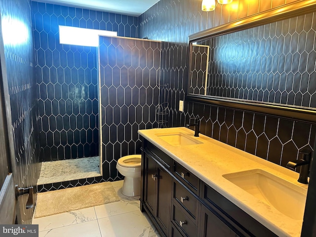 bathroom featuring vanity, toilet, a tile shower, and tile walls