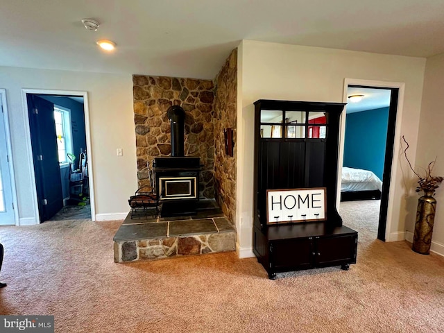 carpeted living room featuring a wood stove