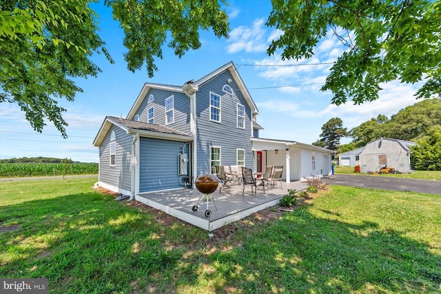 back of house with a yard and a patio