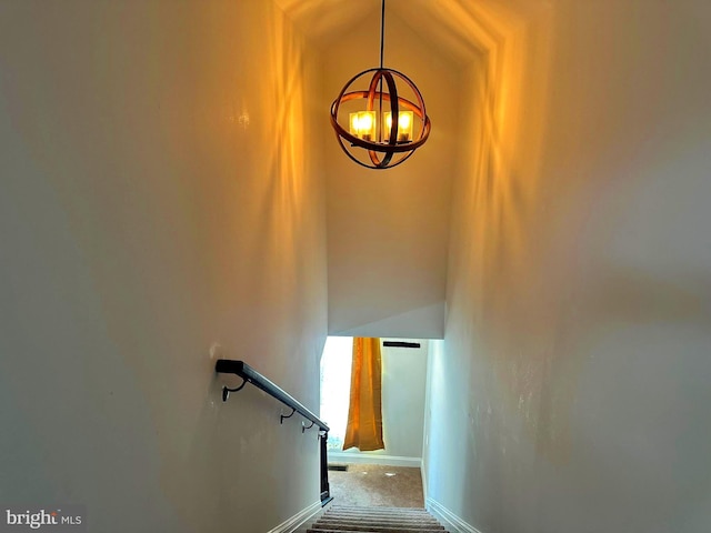 staircase with carpet, vaulted ceiling, and an inviting chandelier