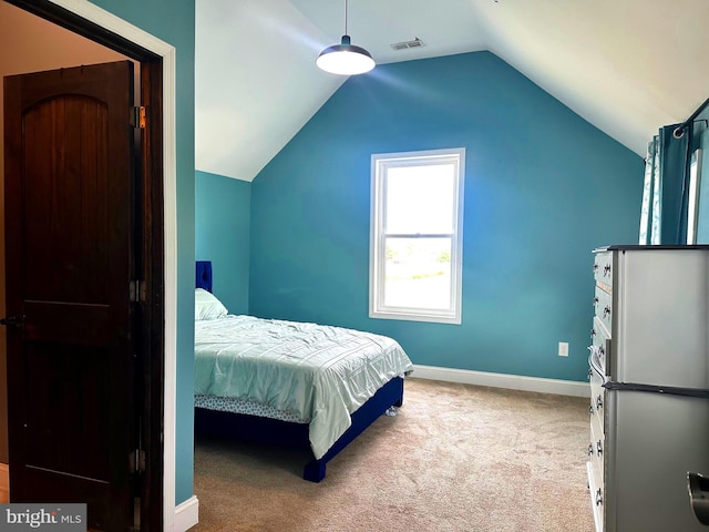 bedroom featuring light colored carpet and vaulted ceiling