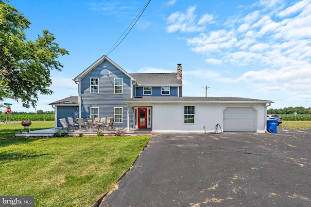 view of front of house with a garage, a patio area, and a front yard