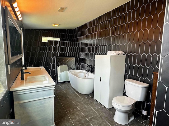 bathroom featuring tile patterned floors, a bathtub, toilet, and tile walls