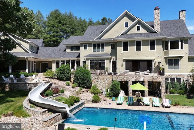 rear view of property featuring pool water feature