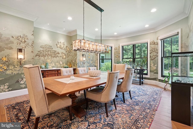 dining area with hardwood / wood-style floors, an inviting chandelier, and crown molding