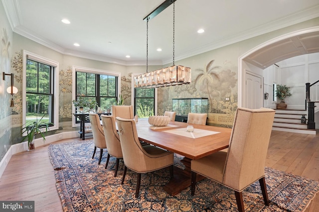 dining space with hardwood / wood-style flooring, an inviting chandelier, and crown molding