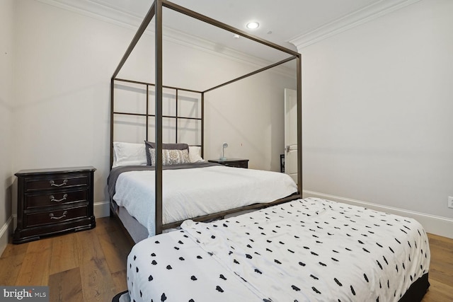 bedroom featuring wood-type flooring and crown molding