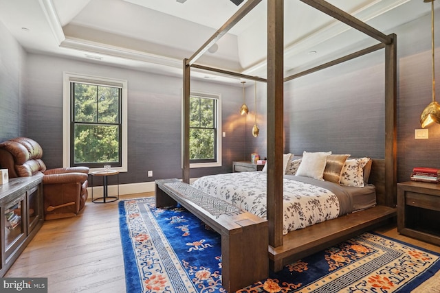 bedroom featuring light wood-type flooring and a tray ceiling