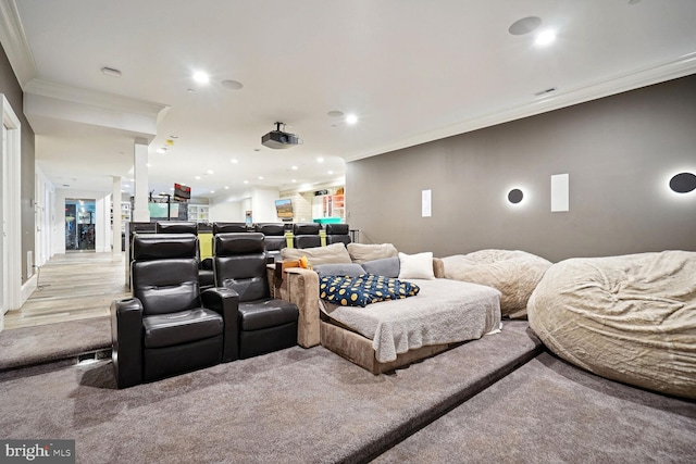 home theater with light colored carpet and crown molding