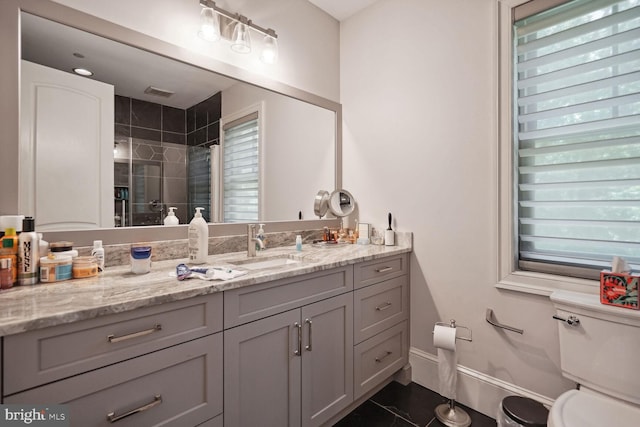 bathroom with tile patterned flooring, vanity, a shower with door, and toilet